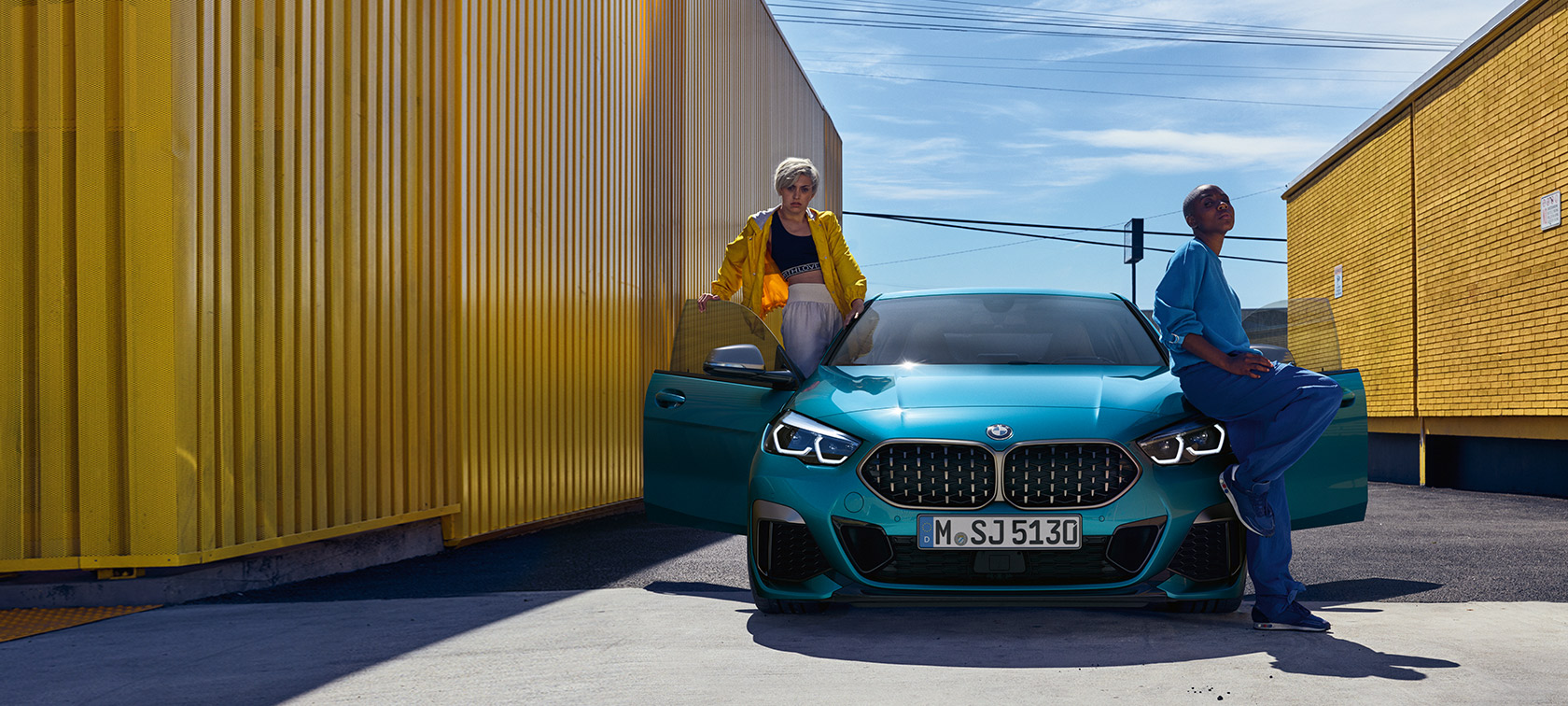 BMW 2 Serisi Gran Coupé F44, Metalik Mavi/Snapper Rocks, içinde iki kişi bulunan kapıları açık otomobilin önden görünümü