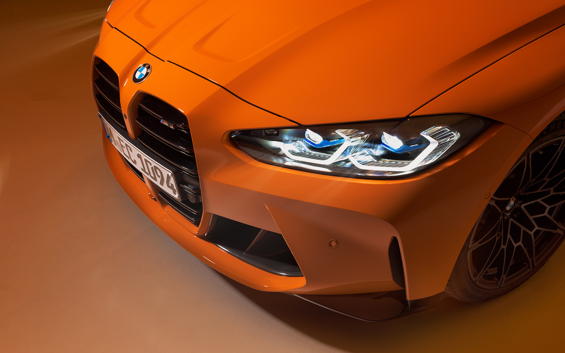 BMW M4 Competition Coupé G82, BMW Individual Metalik Turuncu/Fire Orange, hareketsiz halde ön çaprazdan kuş bakışı yakın plan çekim